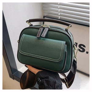 Detail der dunkelgrünen Lederhandtasche mit Kontrastnähten und verstellbarem Riemen