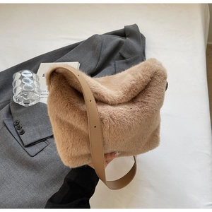 Detail of soft camel faux fur shoulder bag texture with adjustable brown leather strap