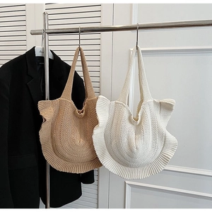 Detail of knitted tote bags with elegant ruffle edges in beige and khaki colors