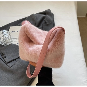 Detail of pink faux fur shoulder bag with soft texture and adjustable leather strap