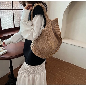 Detail of a large khaki knitted shoulder bag featuring a stylish ruffled edge design