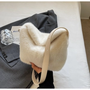 Detail of soft cream faux fur texture and adjustable leather strap on this shoulder bag