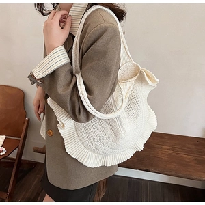 Detail of white handmade crochet tote bag featuring wave pleated edges and mesh texture