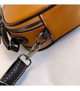 Detail of lychee textured leather bag with gunmetal hardware and contrast stitching