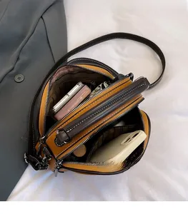 Detailed interior view of multi-compartment leather crossbody bag showing ample storage space