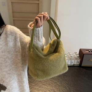 Close-up of moss green plush shoulder bag with smooth faux leather strap and soft texture