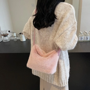 Detail showing plush pink faux fur texture of a crossbody bag in a cozy cafe setting