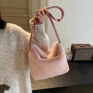 Detail of pink faux fur handbag showing soft plush texture and leather shoulder strap