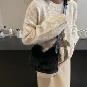 Detail of high-density black faux fur shoulder bag with soft texture and leather strap