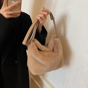 Close-up of soft faux fur shoulder bag with adjustable leather strap in beige