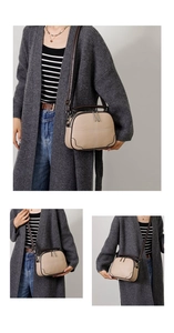 Detail view of beige retro crossbody bag with dual zippers and adjustable shoulder strap