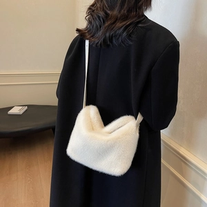 Close-up of white plush faux fur shoulder bag with U-shape design and long strap