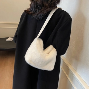 Close-up of white faux fur texture and leather strap on this large shoulder bag