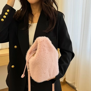 Detailaufnahme einer rosa Plüschbeuteltasche mit Kordelzug und weicher Oberfläche