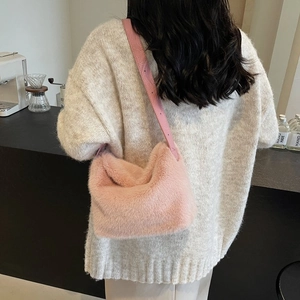 Detail of pink faux fur shoulder bag with leather strap shown in cafe setting
