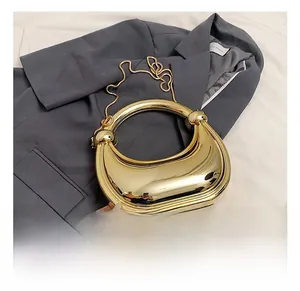 Détail du sac de soirée métallique doré en forme de croissant avec bandoulière