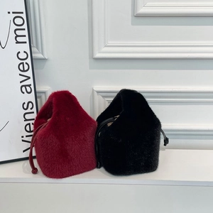Detail von flauschigen Plüsch-Beuteltaschen in Rot und Schwarz mit Kordelzugverschluss