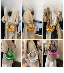 Sac à chaîne chic en or, argent, vert et rose, porté à l'épaule et à la main avec style