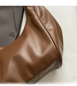 Detailed macro view of soft brown faux leather texture and durable stitching on bag