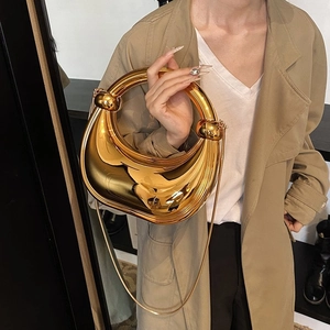 Détail du sac de soirée doré avec poignée ronde et bandoulière chaîne amovible