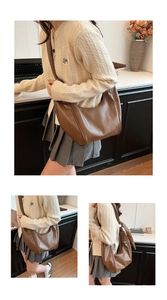 Detail view of large brown hobo bag with wide strap in a minimalist interior setting