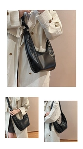 Detail of black semi-circle hobo bag with knotted strap and smooth matte finish