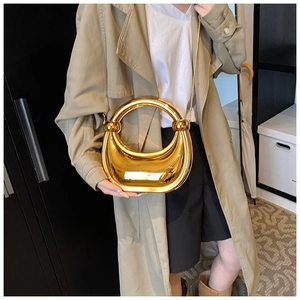 Détail du sac à main en forme de croissant doré avec bandoulière à chaîne chic