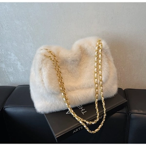 Detail of white faux fur shoulder bag featuring a luxury woven gold metal chain strap