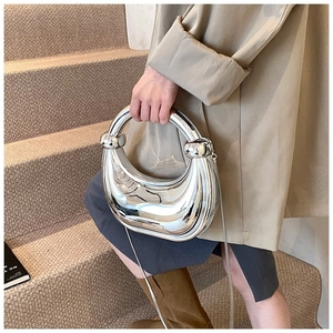 Détail de la pochette demi-lune argentée effet miroir avec une bandoulière chaîne élégante