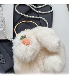 Close-up of white plush rabbit handbag with carrot embroidery and gold metal handles