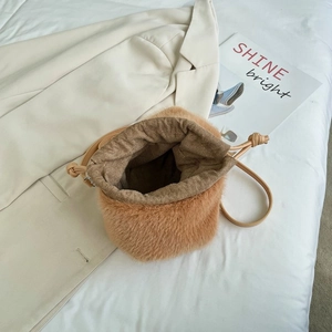 Braune Plüsch-Beuteltasche mit Kordelzug und Umhängeriemen in modischer Umgebung
