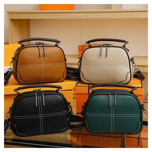Detail view of four colors of retro crossbody bags with cross-stitch and twin zippers