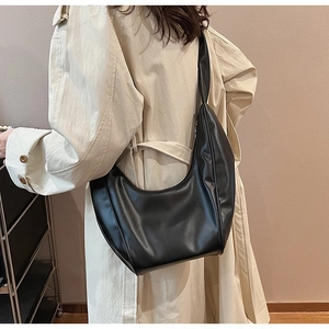 Chic black hobo bag styled with a beige trench coat for a minimalist fashion look