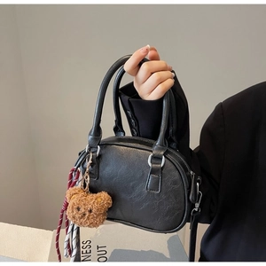 Minimalist black faux leather handbag with cute bear charm and woven rope decoration