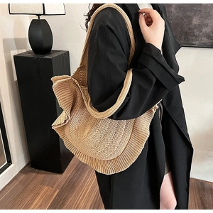 Minimalist straw tote bag with ruffled edges in khaki, shown on a model for summer style