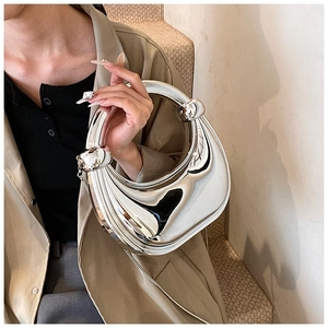 Vue détaillée du sac à main argenté effet miroir avec nœuds métalliques et poignée chic