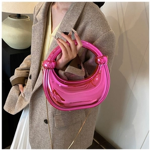 Gros plan du sac de soirée rose métallisé avec poignée nouée et bandoulière dorée