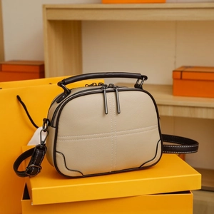Detail of contrast stitch handbag with lychee texture leather on a yellow box