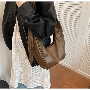 Detailed side view of caramel PU leather hobo bag with sleek stitching and wide strap