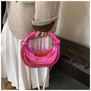 Détail du sac demi-lune fuchsia métallisé avec poignée nouée et fine chaîne dorée