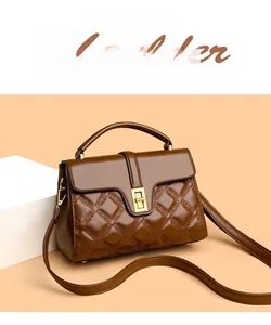 Close-up of brown quilted leather handbag with golden rectangular twist lock hardware