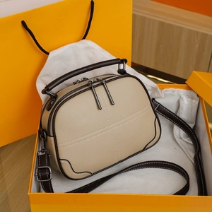 Detail view of contrast stitch square handbag with textured leather in orange gift box