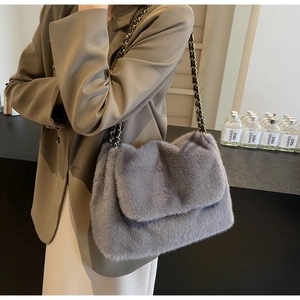 Detail of grey faux fur tote bag with golden chain strap and soft plush texture