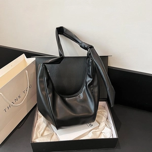 Detail of black Hobo bag with knotted shoulder strap in a premium gift box setup