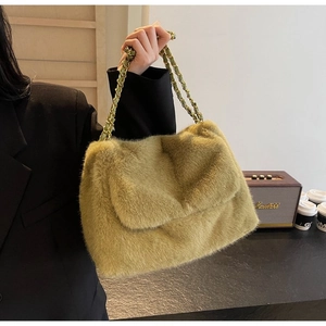 Detail of olive green faux fur shoulder bag with gold chain strap in a lifestyle setting