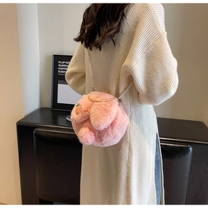 Détail du sac en fausse fourrure rose avec bandoulière perle et décor de carotte