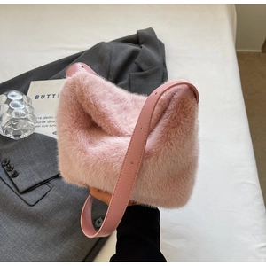Chic pink plush hobo bag with adjustable leather strap styled on a grey blazer suit