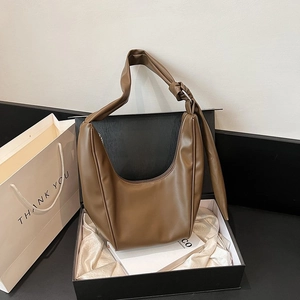 Detail of a dark brown PU leather crescent shoulder bag inside a luxury gift box with silk