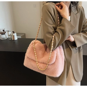 Pink faux fur tote bag with gold chain strap detail shown in a lifestyle setting