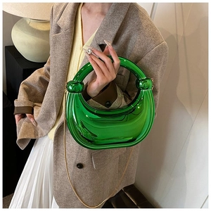Détail du sac croissant vert émeraude métallisé avec chaîne dorée et nœuds sphériques